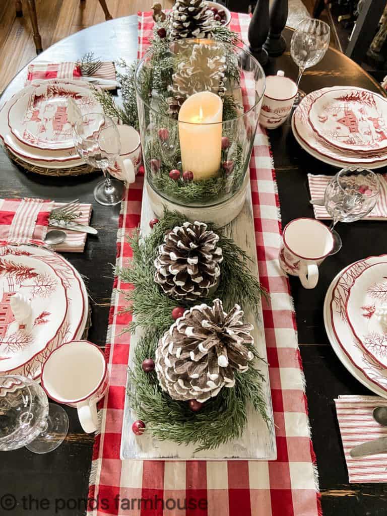 Foraged Pinecones and mini cedar wreath have faux flocking for a snowy look as the tables centerpiece on DIY Table Riser