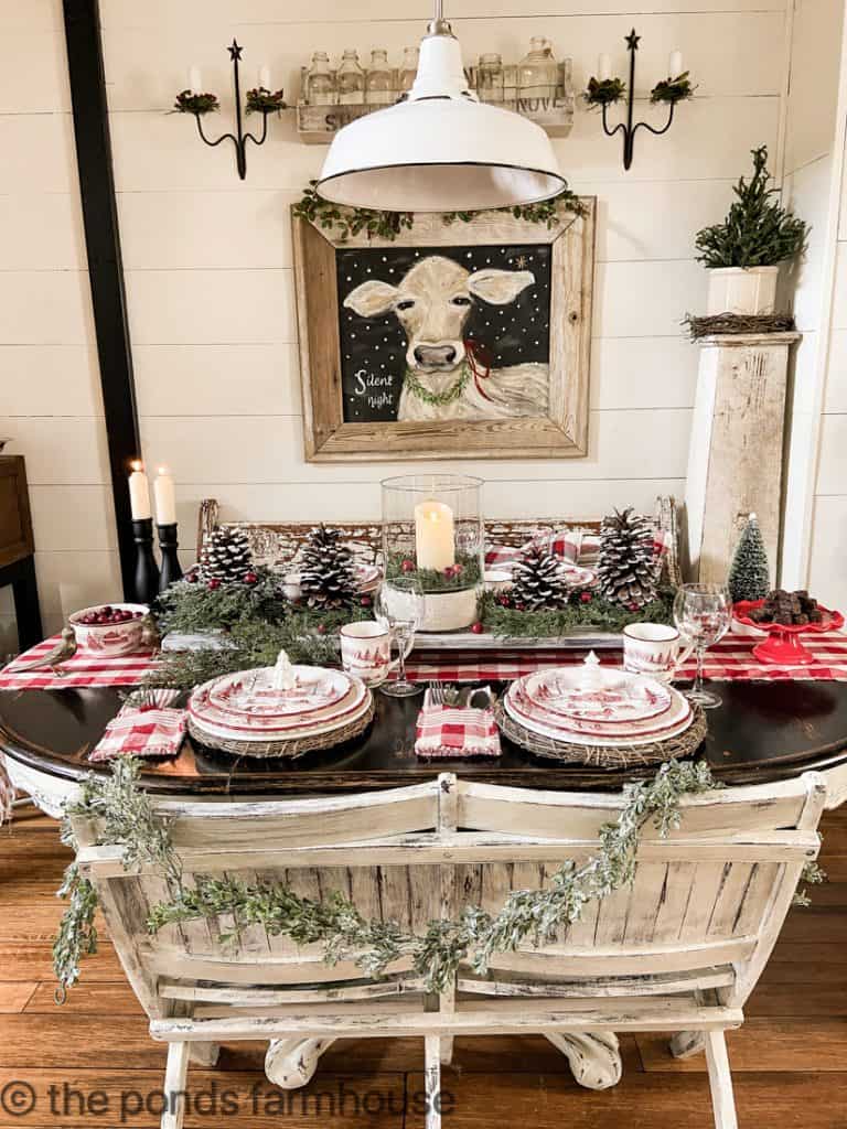 Vintage Bench draped with garland, a Thrifted Hurricane Lantern with foraged pinecones & DIY Table Riser for Creative Tablescape Ideas