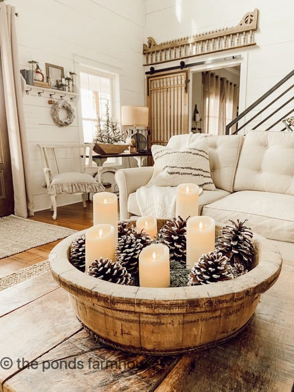 Vintage wooden bowl filled with foraged pinecones and flicker battery candles for a winter decoration idea for coffee tables.