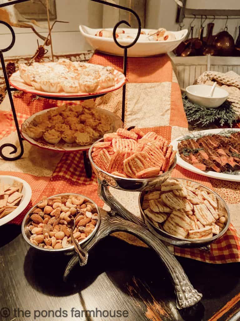 Set table with risers to keep food at different levels for party entertaining.