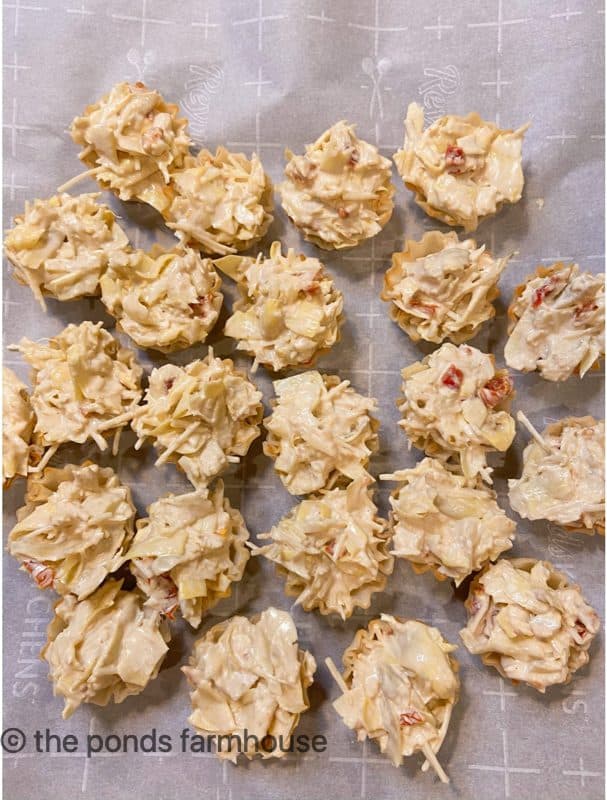 Fill phyllo cups with ingredients forArtichoke & Sun-Dried Tomato Bites Recipe