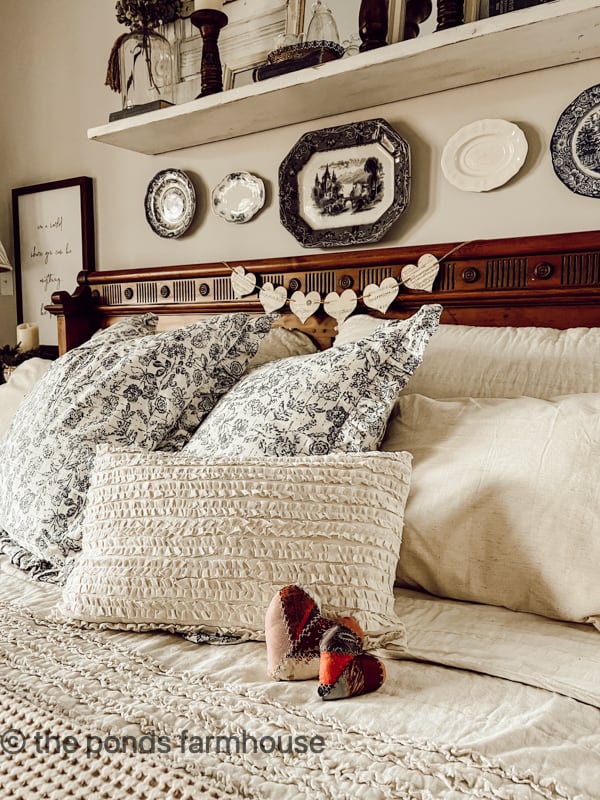 Farmhouse Winter Decor in Bedroom with woods and whites.  Country style bedding and DIY hearts