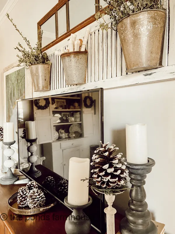winter pinecones, brass and candles help to cozy the bedroom feel.  