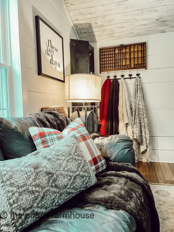A wall of throw blankets are ready to add warmed in the cozy industrial style loft.