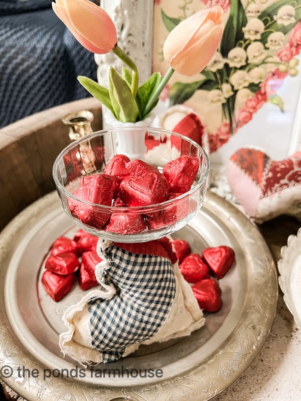 Add candy hearts and vintage quilt hearts under a glass cloche for a Valentines Day Vignette with Cloches.