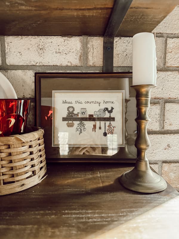 Bring the cottagecore aesthetic into your home this year by thrifting for handcrafted needle work art such as framed cross stitch pieces.