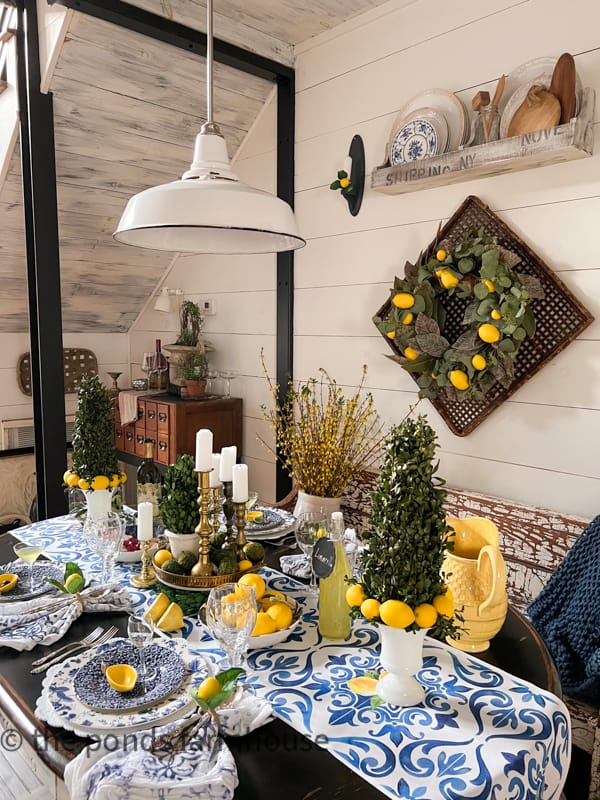 Full view of dinner table with Italian Dinner Party Theme. blue and white dishes, lemon accessories & DIY Boxwood Topiaries