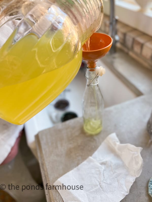 Pour Limoncello Recipe into decorative bottles using a funnel.  