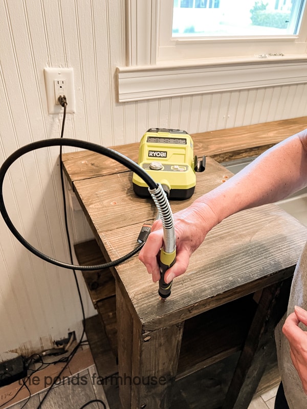 Filling in the counter sunk holes on the countertop during DIY Budget-friendly handmade rustic kitchen cabinets.