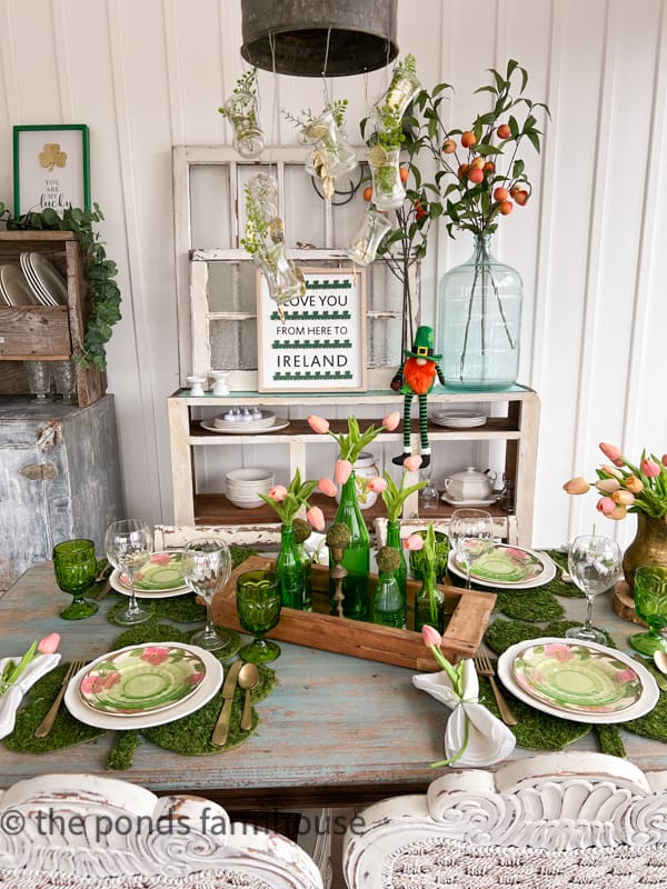 St Patrick’s Day tablescape with decorations. Moss place mats and floral plates.