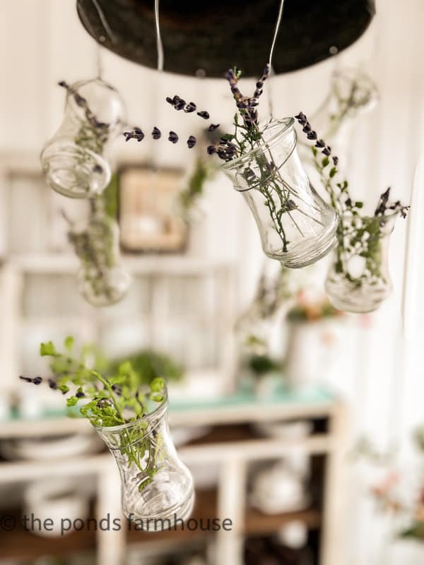 DIY light fixture with hanging vases filled with greenery and lavender is one of the Spring Table Ideas. 