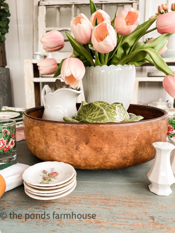 vintage wood bowl centerpiece filled with ironstone, milk glass and tulips for a beautiful table setting for Spring.