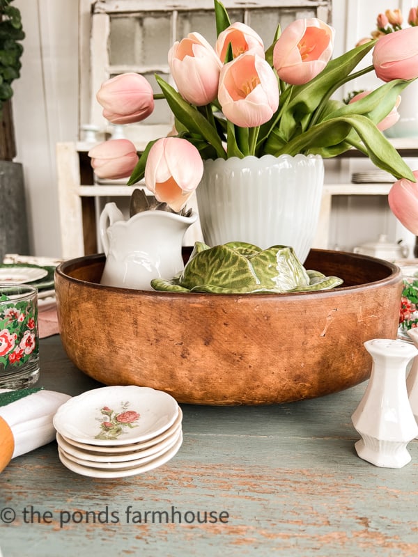 Large pink tulips in milk glass vase inside a thrifted wooden bowl