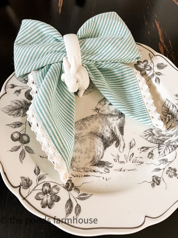 How to make Bow Tie Napkin Fold with a striped napkin and bunny napkin rings on a Easter Plate.