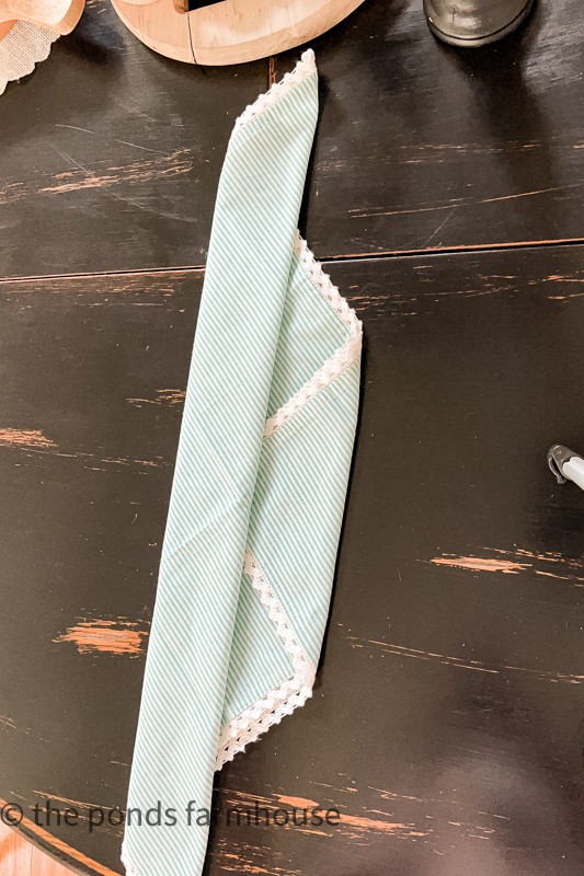 napkin fold step by step tutorial with blue and white striped napkin.