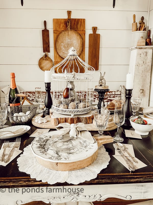 Easter table with pewter bunny sitting on candlesticks holder.