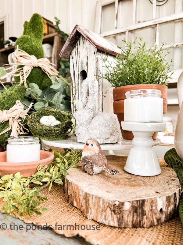 Easter Centerpiece Ideas. Bird house on dining table and bird on wooden riser. Moss Easter Bunny.