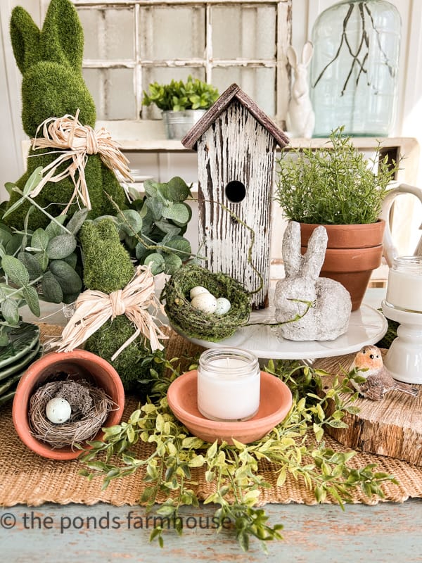 Spring table centerpiece with clay saucers and ceramic cupcake holders for candlesticks holders.