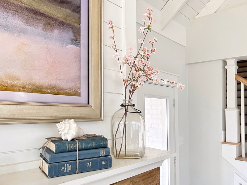 Old Barn company with vintage jar filled with cherry blossoms and old books with shell. 