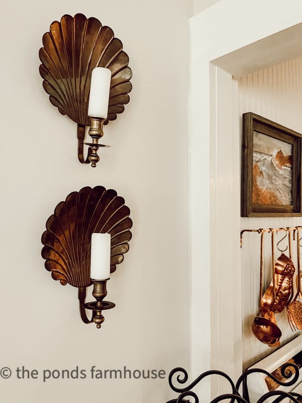 Thrift Store Vintage Brass Shelll Wall Sconces with white candles hanging over the bar in the tiny beach cottage remodel.  