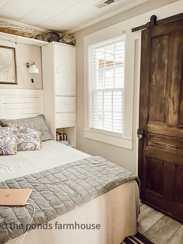 Small Bedroom with repurposed old door as barn door with blue and white bedding in Tiny house beach cottage.