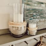 thrifted vases with rattan filled with sand and candleholders