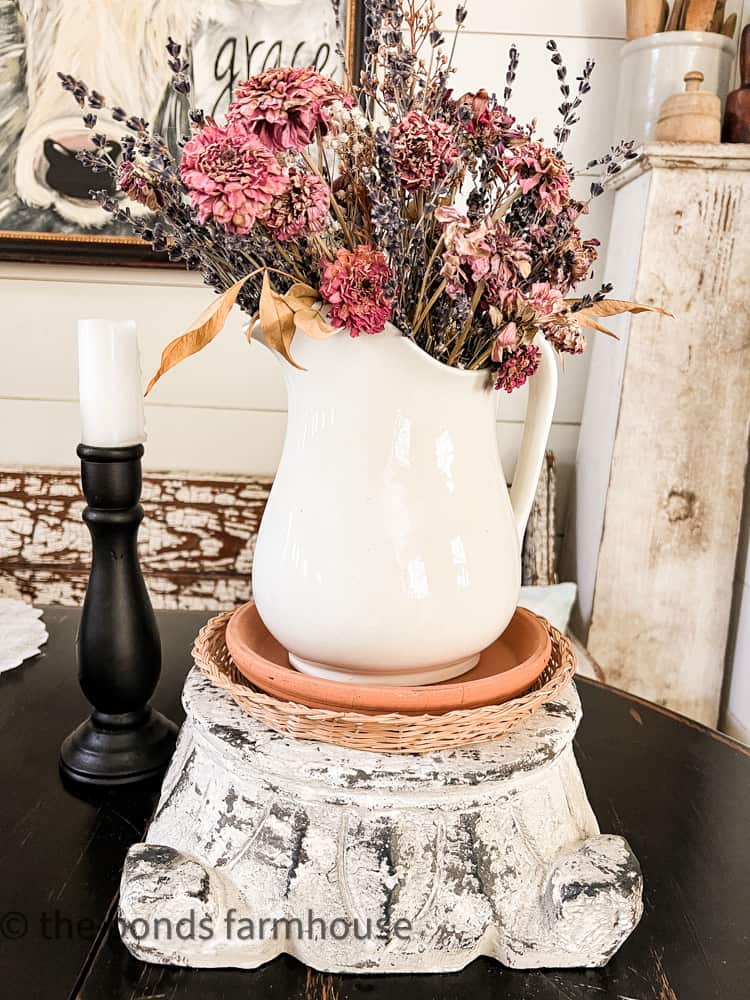 Stack wicker plates with clay saucer and florals on top of a riser.  