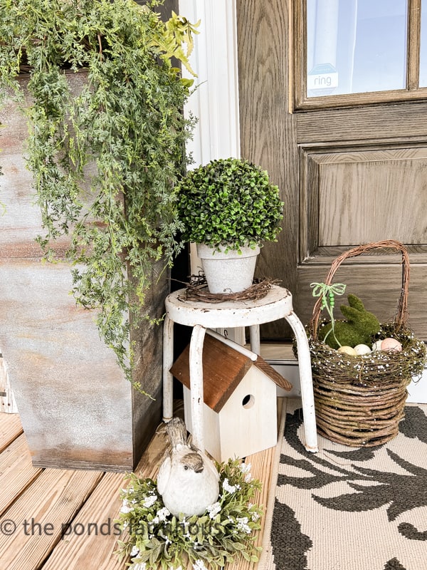 Spring Farmhouse Vignette on porch. Large Easter basket with eggs.