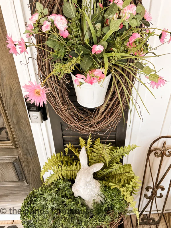 Front Porch Ideas for Spring. Concrete bunny with black shutters and hanging basket.