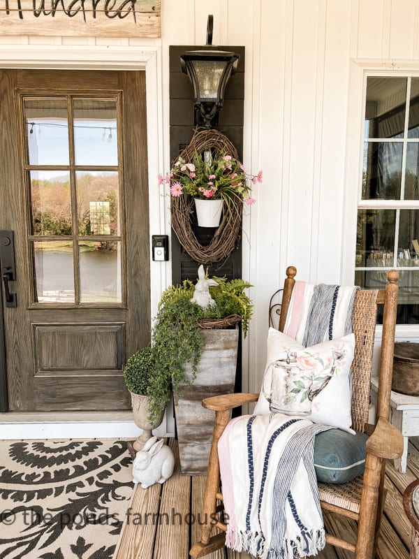 Shutters and planter filled with farmhouse style spring decor.