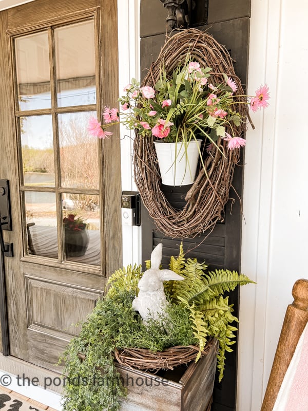 Spring Wreath with oval grapevine and white bucket with pink flowers on DIY shutter.  