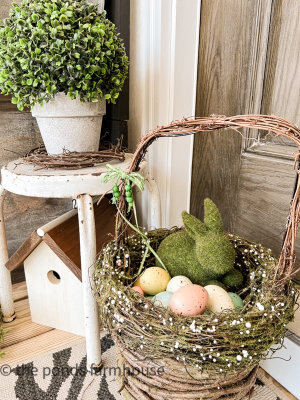 Moss Bunny in twig basket for Spring. Colored eggs in basket.