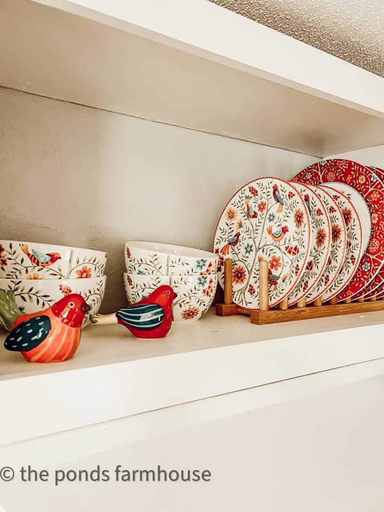 Cubby Shelves in Kitchen filled with colorful red and white dishes and bird salt and pepper shakers