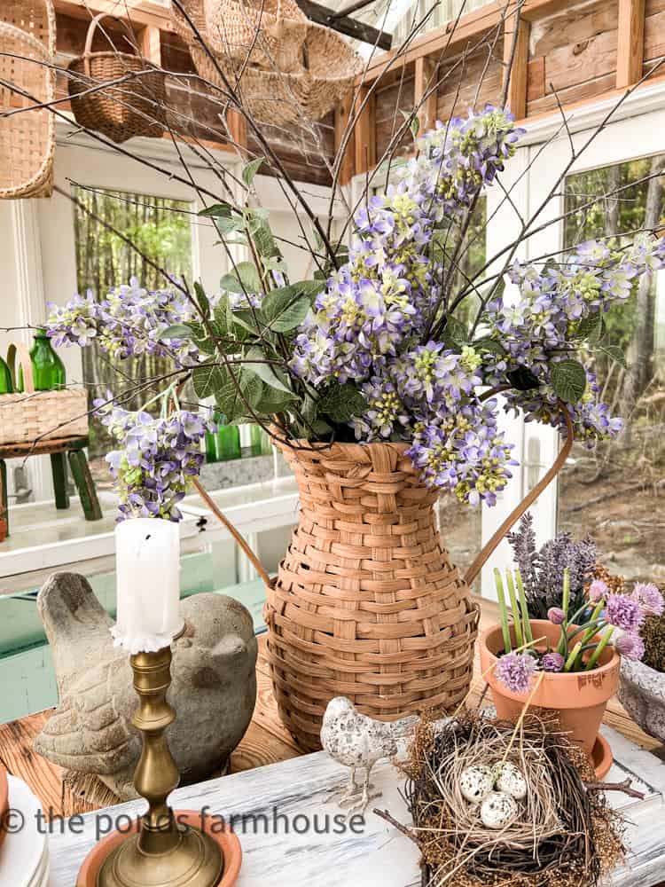 DIY Woven Basket Vase filled with faux lilac blooms in she shed for a  basket decor idea spring vignette.  