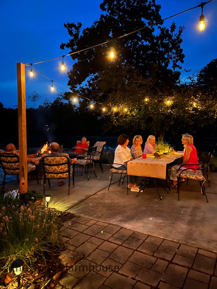 Relaxing evening at a Low Country Boil Party here at The Ponds Farmhouse. Outdoor lighting. Friends around fire pit .