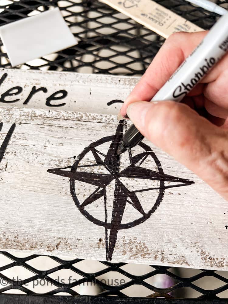 hand draw the compass for the GPS sign. Freehand painting navigational sign compass.