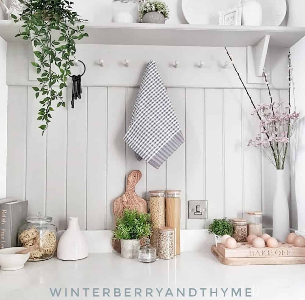 Shaker style peg rail shelf painted gray with a tongue and groove wall for a cottage-style decor.