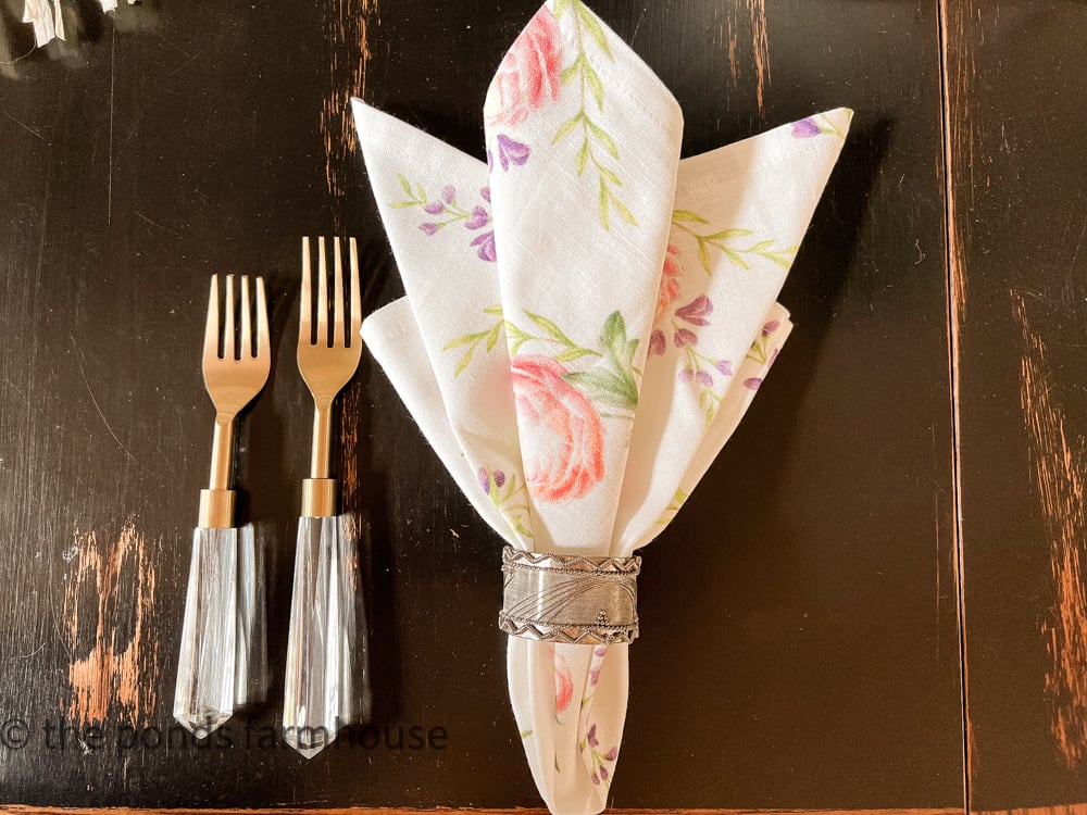 tulip napkin fold with napkin ring, folded tulip napkin place settings with gold and acrylic cutlery.