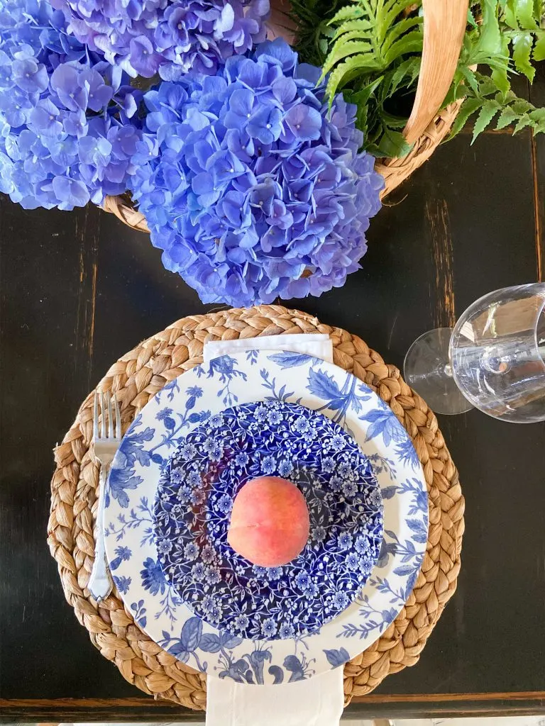 Summer Tablescape with blue and white place setting with fresh peach.
