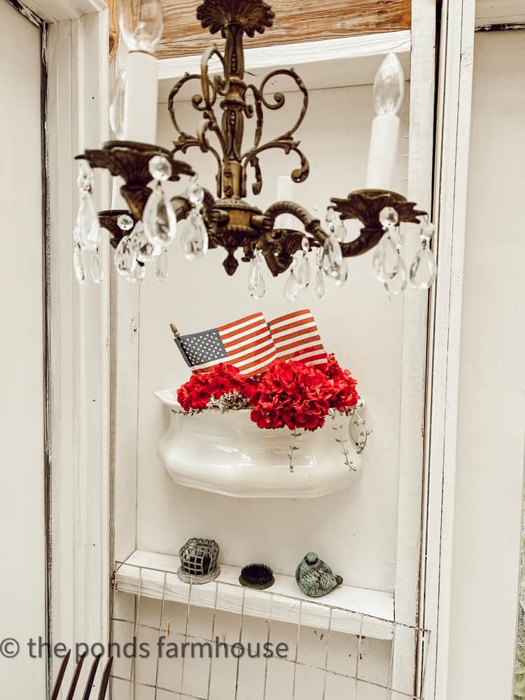 Vintage Thrift Store Find chandelier with planter filled with patriotic flags 