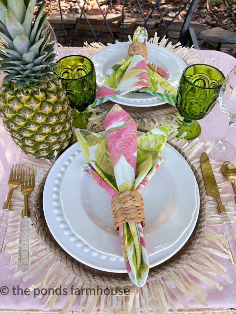 Floral tropical napkins look perfect on white plates for a Luau Party with budget-friendly decorating ideas.