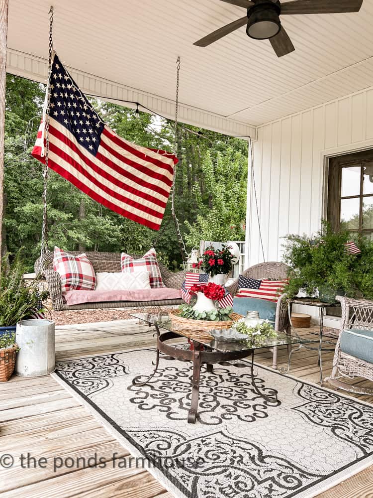 Vintage American Flag over porch swing for patriotic porch decorations, outdoor rug, iron coffee table