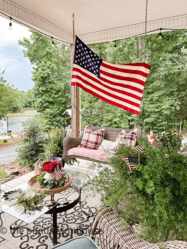 Patriotic-Porch -4th of July Decorating on a Budget with thrift store finds American Flag on porch swing.