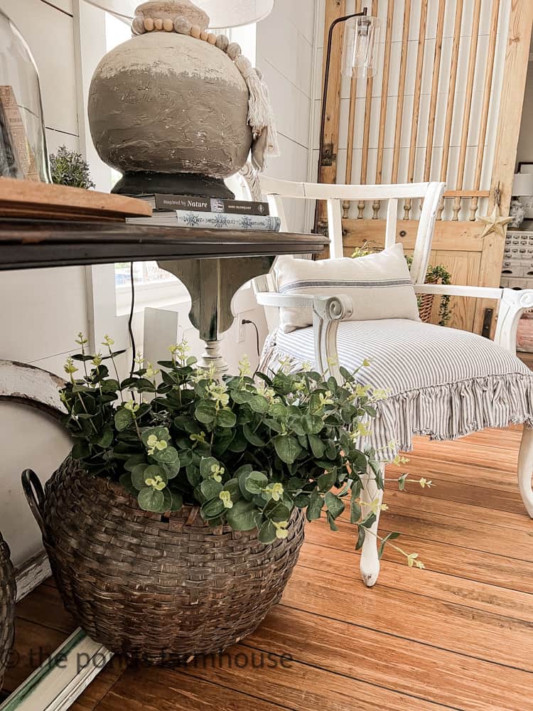 Neutral shades of blue in the ticking stripe chair cushion. Vintage basket with flowers.