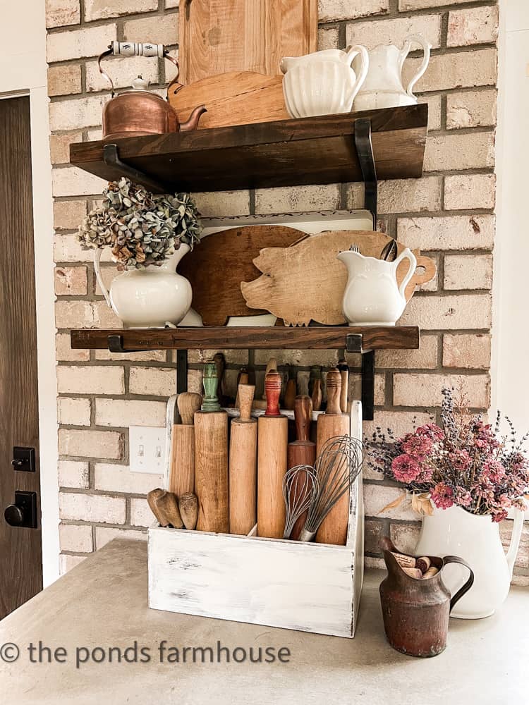 Dried hydrangeas add shades of blue colors to the open shelving.  Vintage rolling pens.