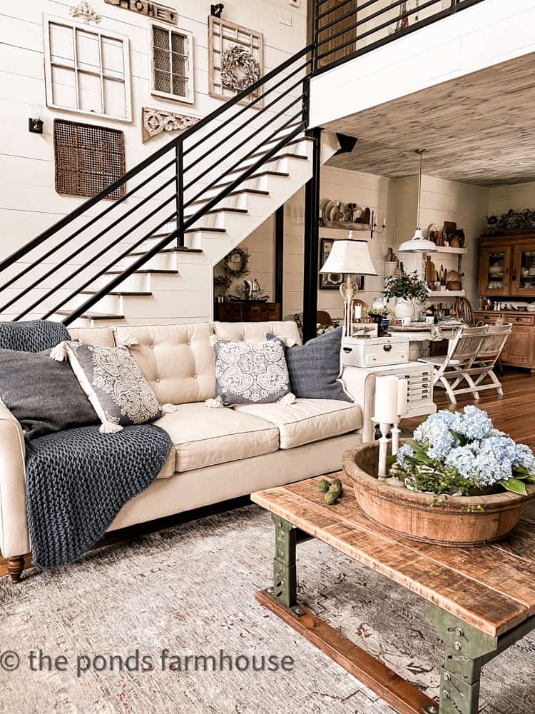 Shades of blue pillows and throw blanket compliment the blues in the rug