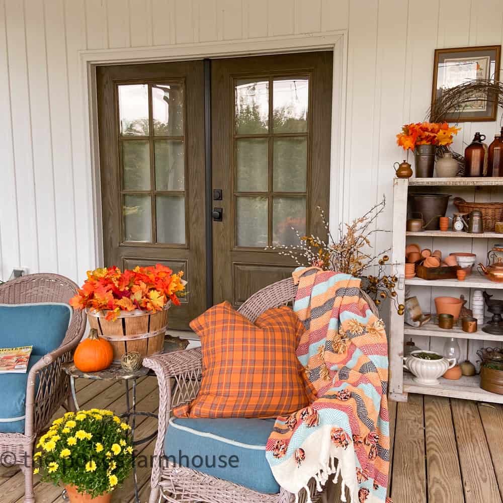 Cozy blanket on vintage wicker seating area on front porch.