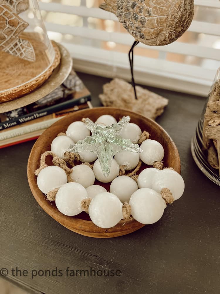 Bowl filled with glass beads and glass starfish ornament for coastal decor ideas.  