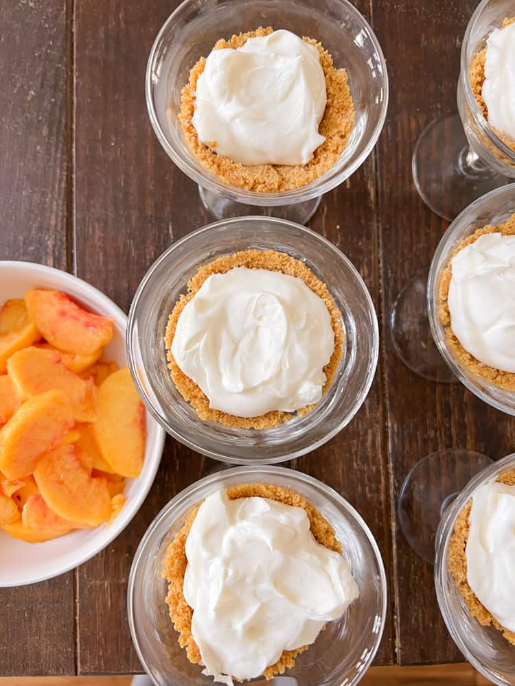 Fill graham cracker crust with dreamy cream filling inside parfait bowl for peach dessert recipe