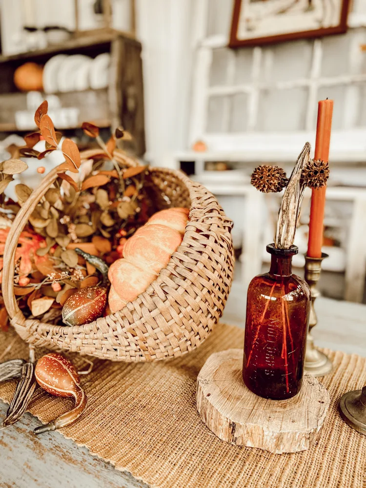 Centerpiece with amber bottles and sweet gum balls.  Vintage handcrafted basket Ideas for Fall Baskets